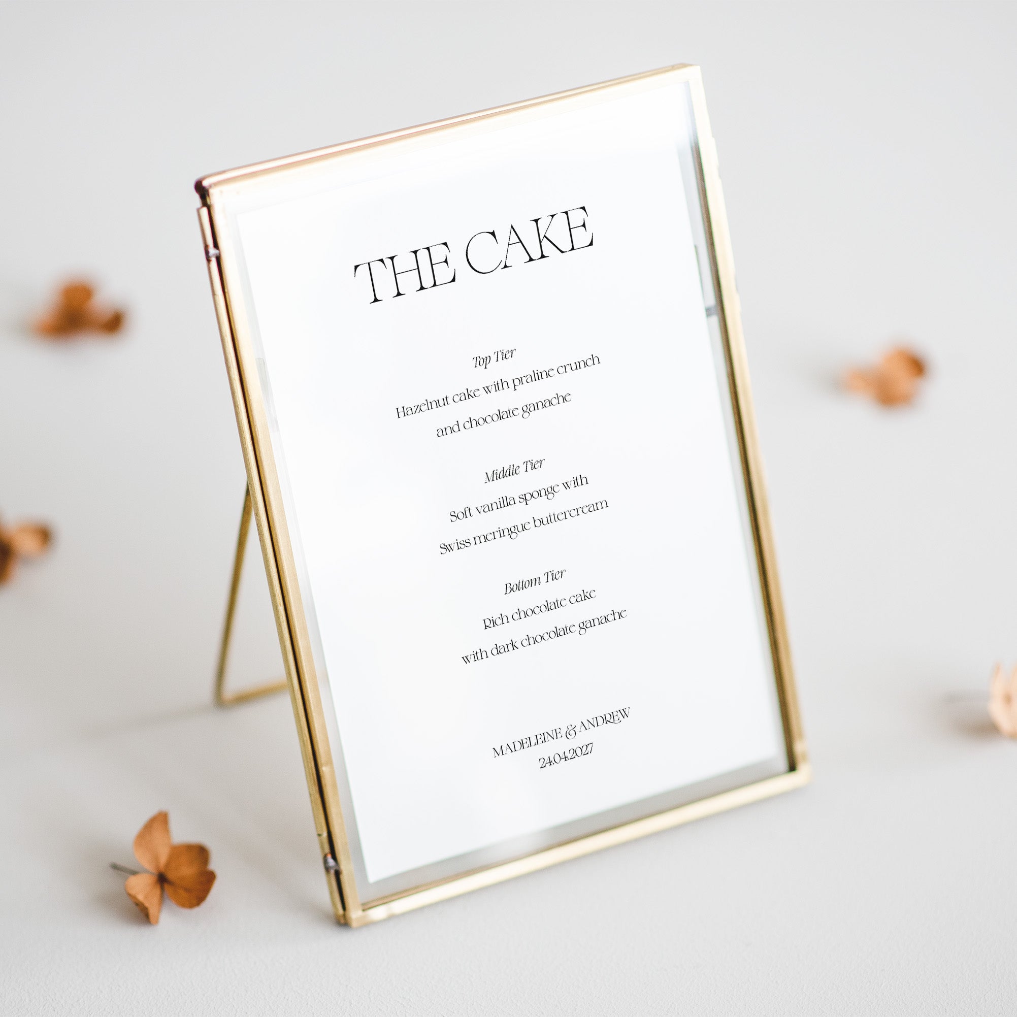 Gold-framed cake flavour menu for wedding on a light background