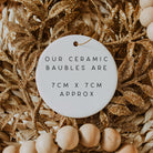 Ceramic bauble with text on a decorative background