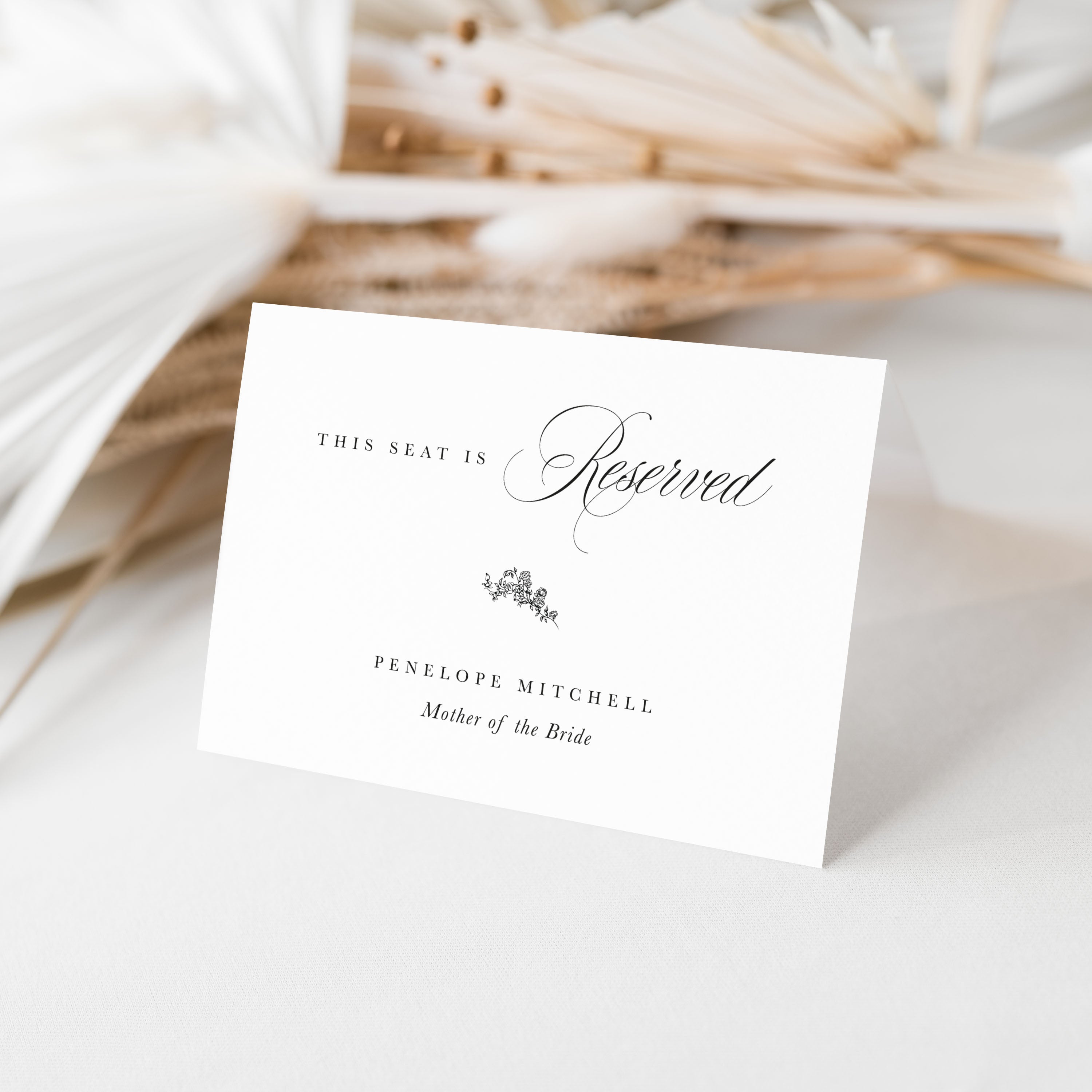 Reserved seating card for a wedding with decorative text on a light background