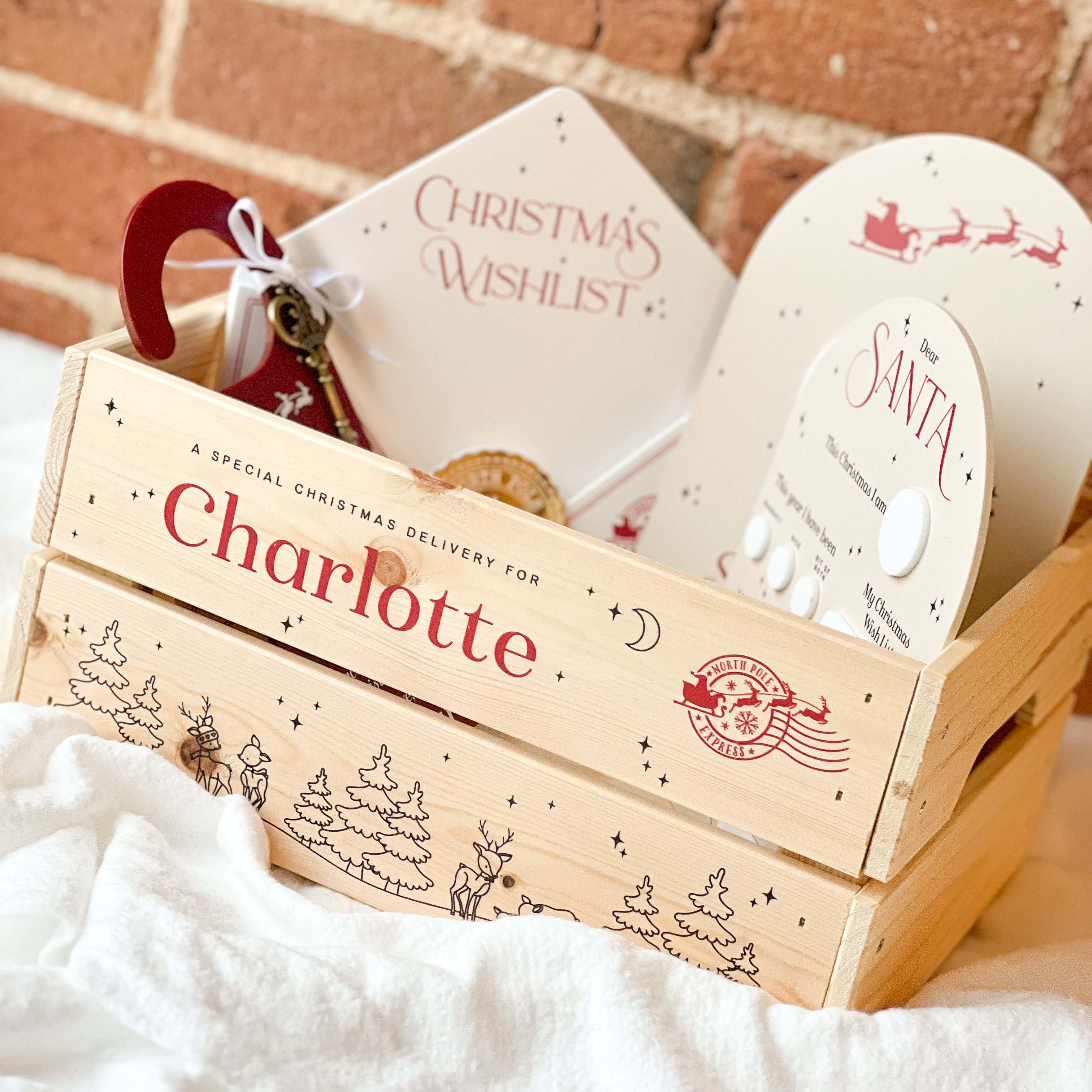 Wooden Christmas Eve gift box with 'Charlotte' on it, containing a 'Christmas Wishlist' card and other festive items.