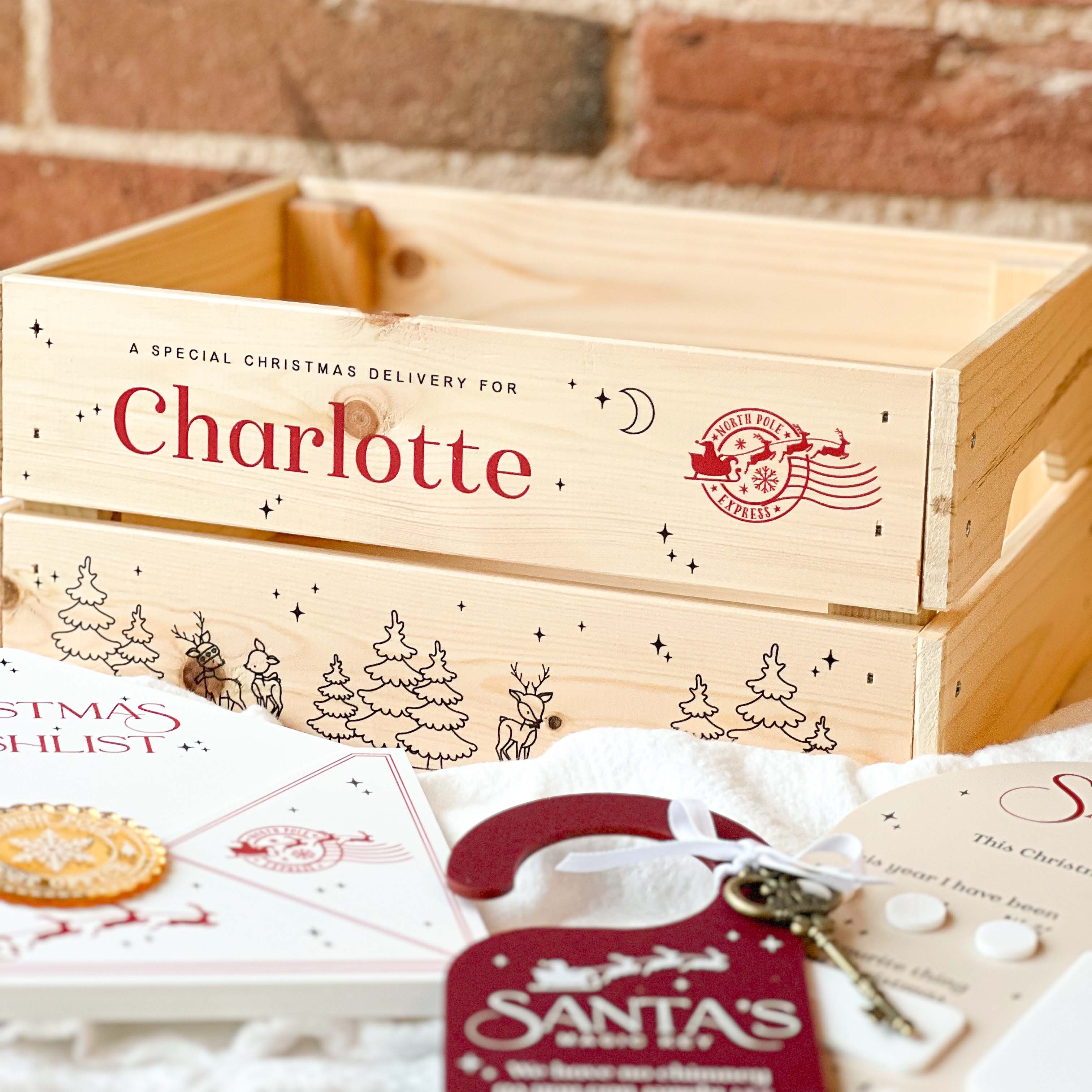 Wooden Christmas box with personalised name 'Charlotte' against a brick wall background.