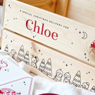 Wooden Christmas Eve gift box with 'Chloe' personalised on it, featuring winter-themed illustrations.