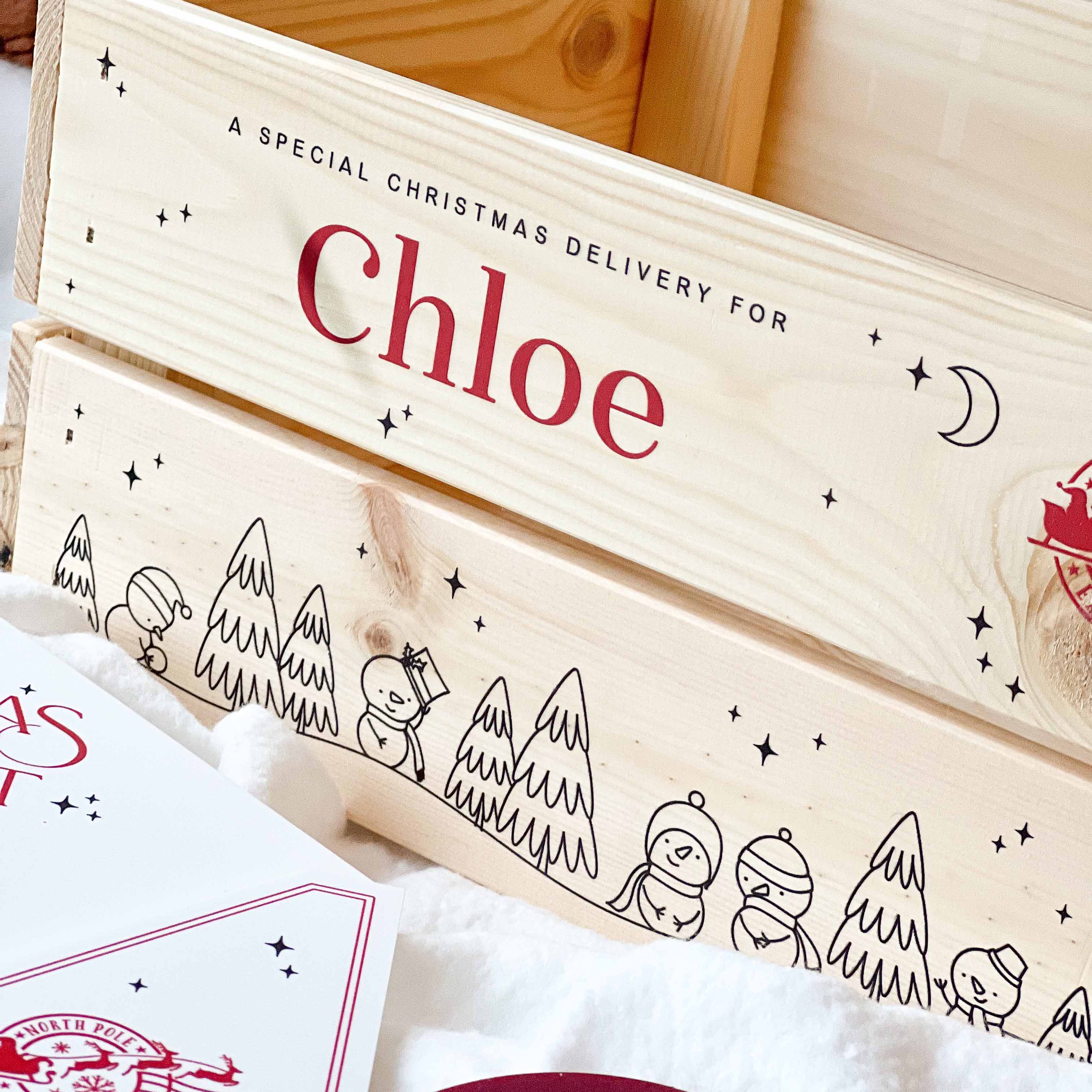 Wooden Christmas Eve gift box with 'Chloe' personalised on it, featuring winter-themed illustrations.
