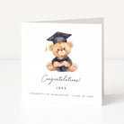 Graduation-themed card with a teddy bear wearing a cap and gown on a white background