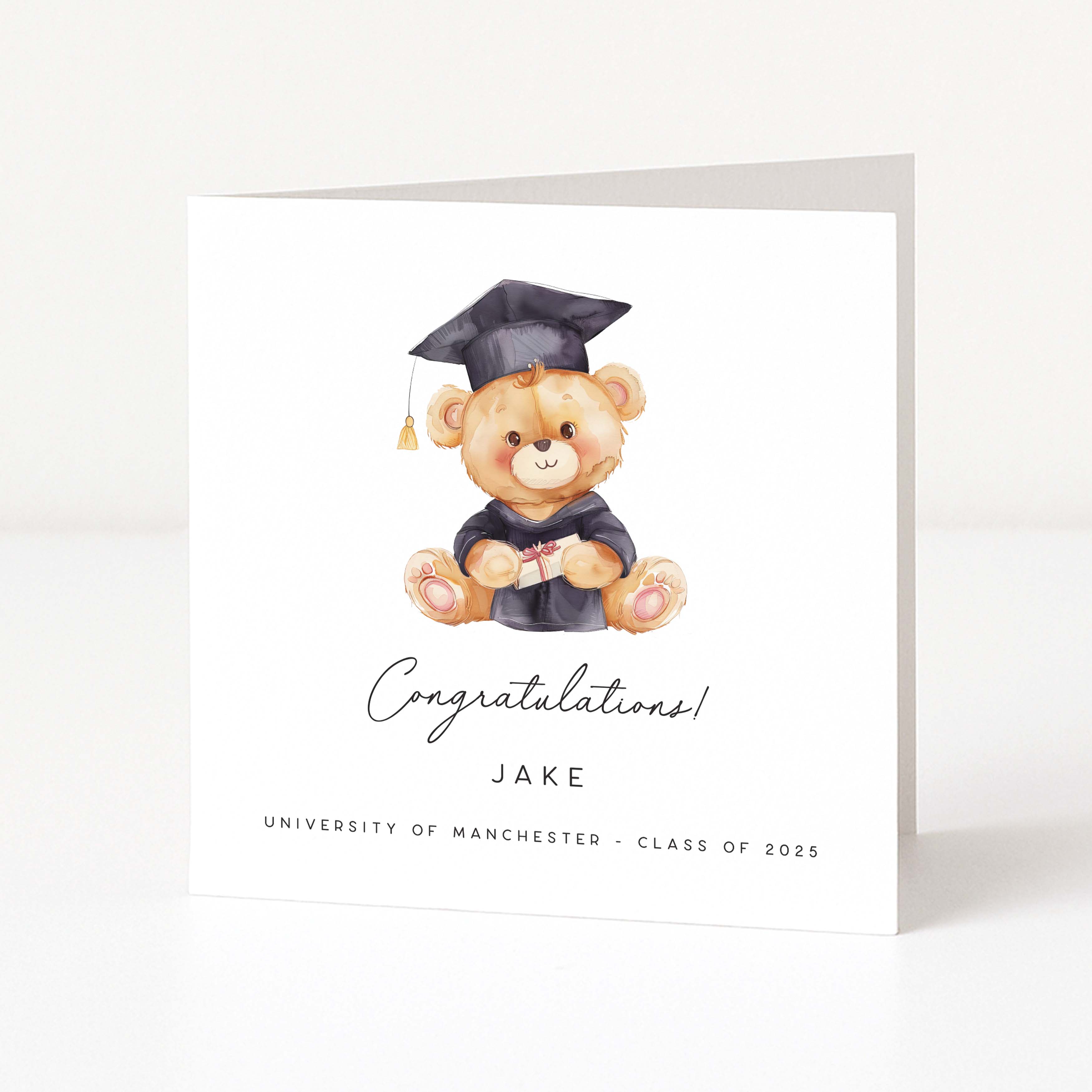 Graduation-themed card with a teddy bear wearing a cap and gown on a white background
