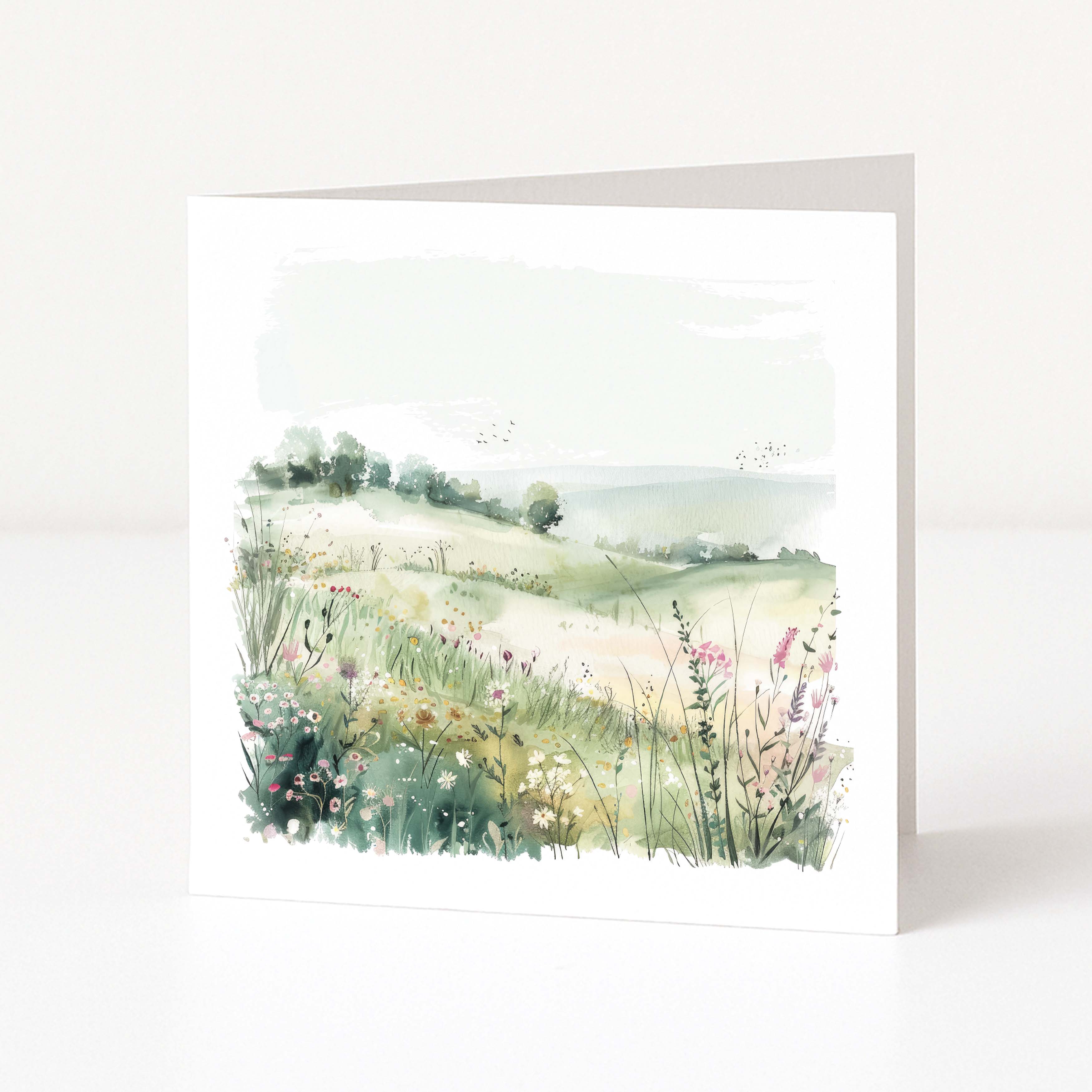 Greeting card with a scenic illustration of a field and trees on a white background