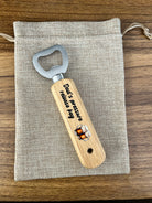 Wooden bottle opener with engraved text on a fabric pouch