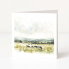 Greeting card with a landscape of cows in a field on a white background