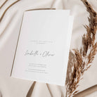 Wedding order of service card on a soft fabric background with dried grasses.