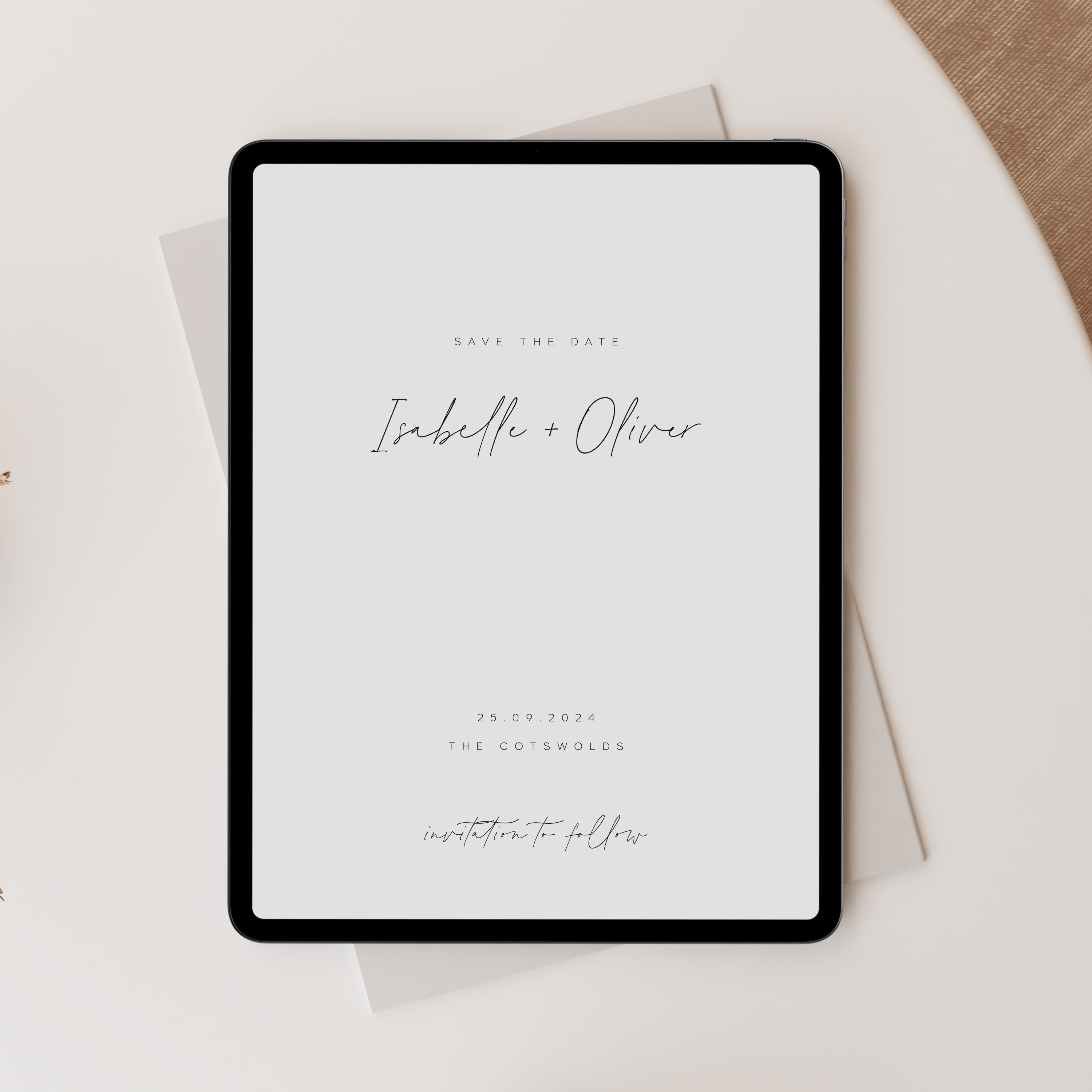 Digital tablet displaying a minimalist wedding save the date design with 'Isabelle + Oliver' on a light background.