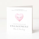 Engagement card with a pink heart and personalized text on a white background