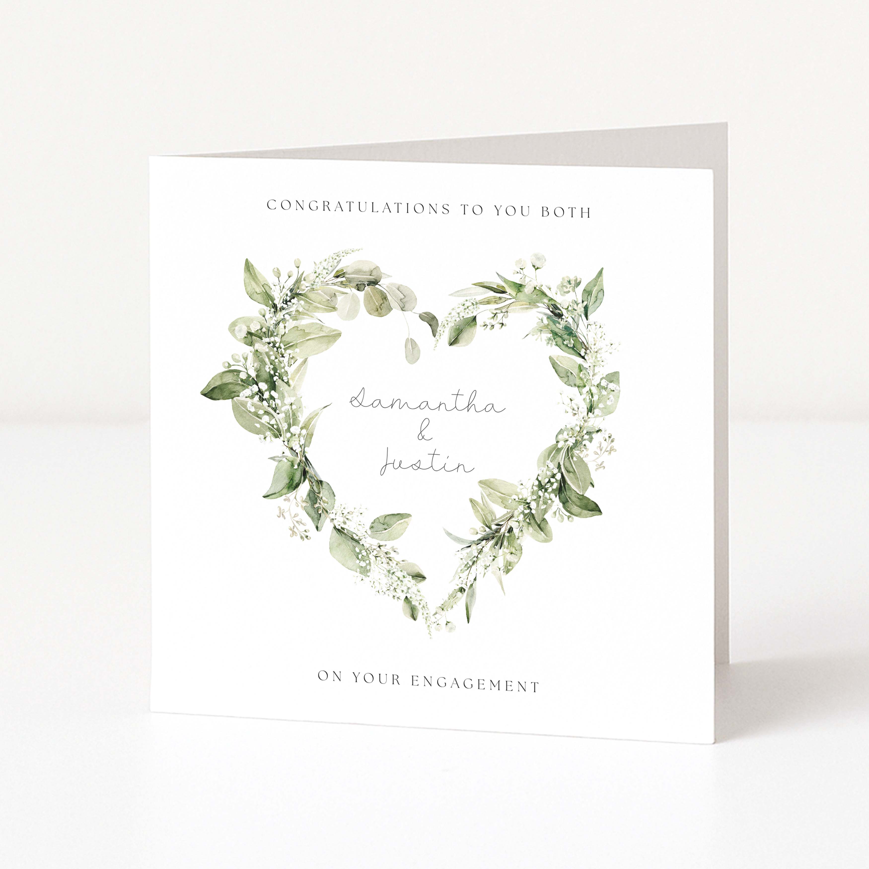 Engagement card with green leaf wreaths and personalized names on a white background