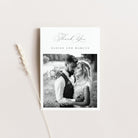 Wedding thank you card with a black and white photo of a couple on a light gray background.