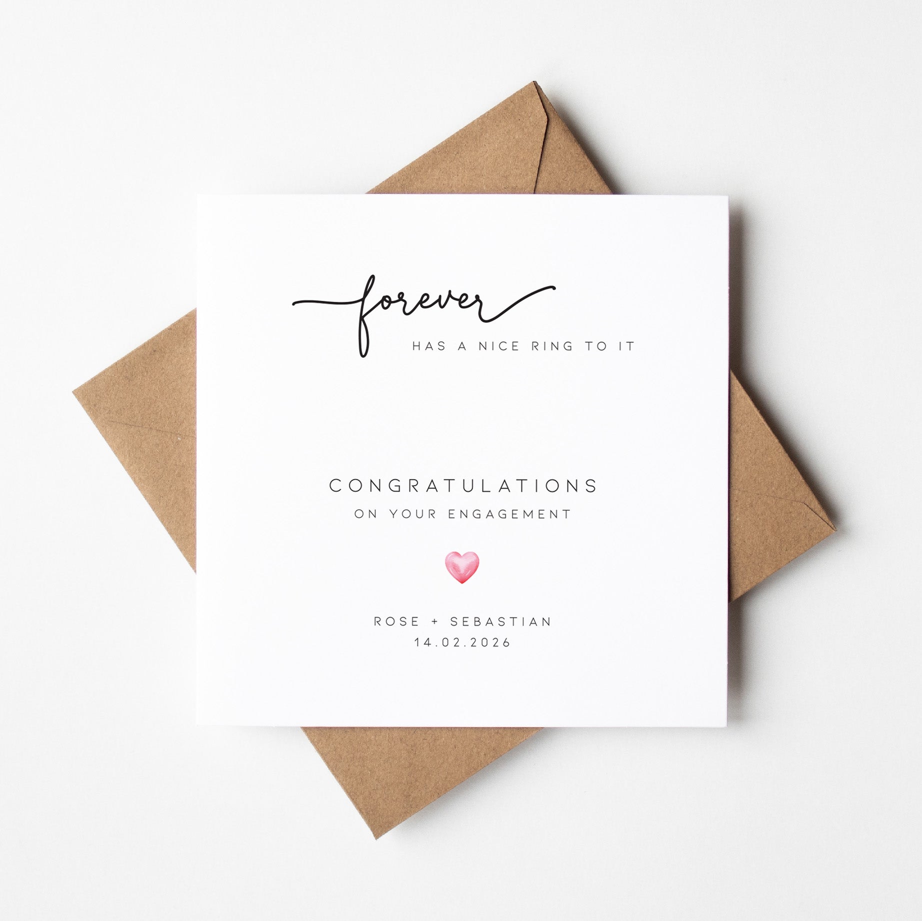 Engagement card with 'forever has a nice ring to it' text and a heart symbol, placed on a white background.