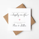 Engagement card with 'happily ever after' text and a heart symbol, accompanied by a brown envelope on a white background.