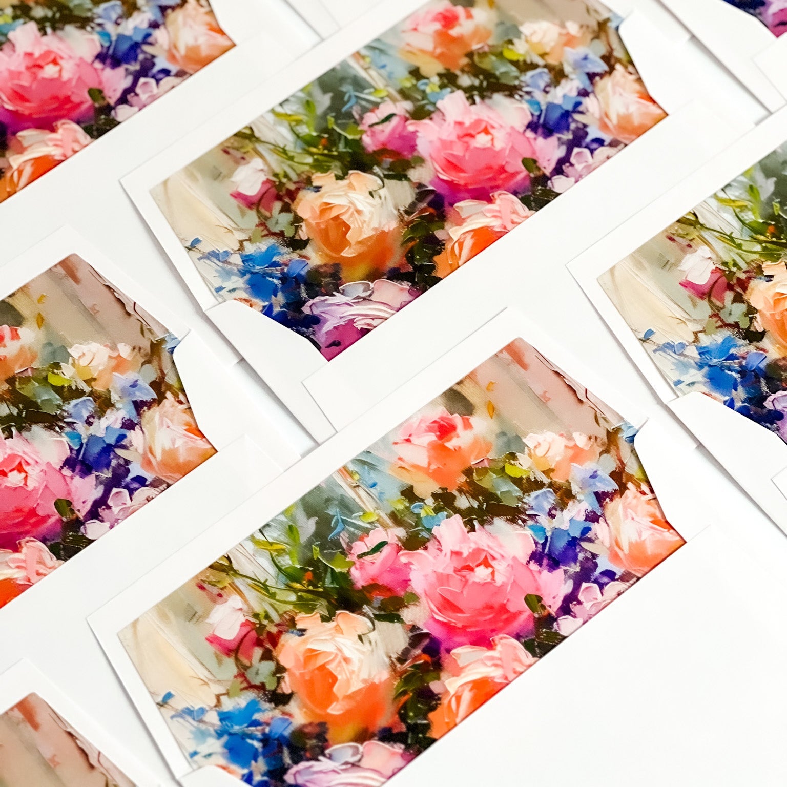 Collage of colourful floral envelope liners in white straight flap envelopes.