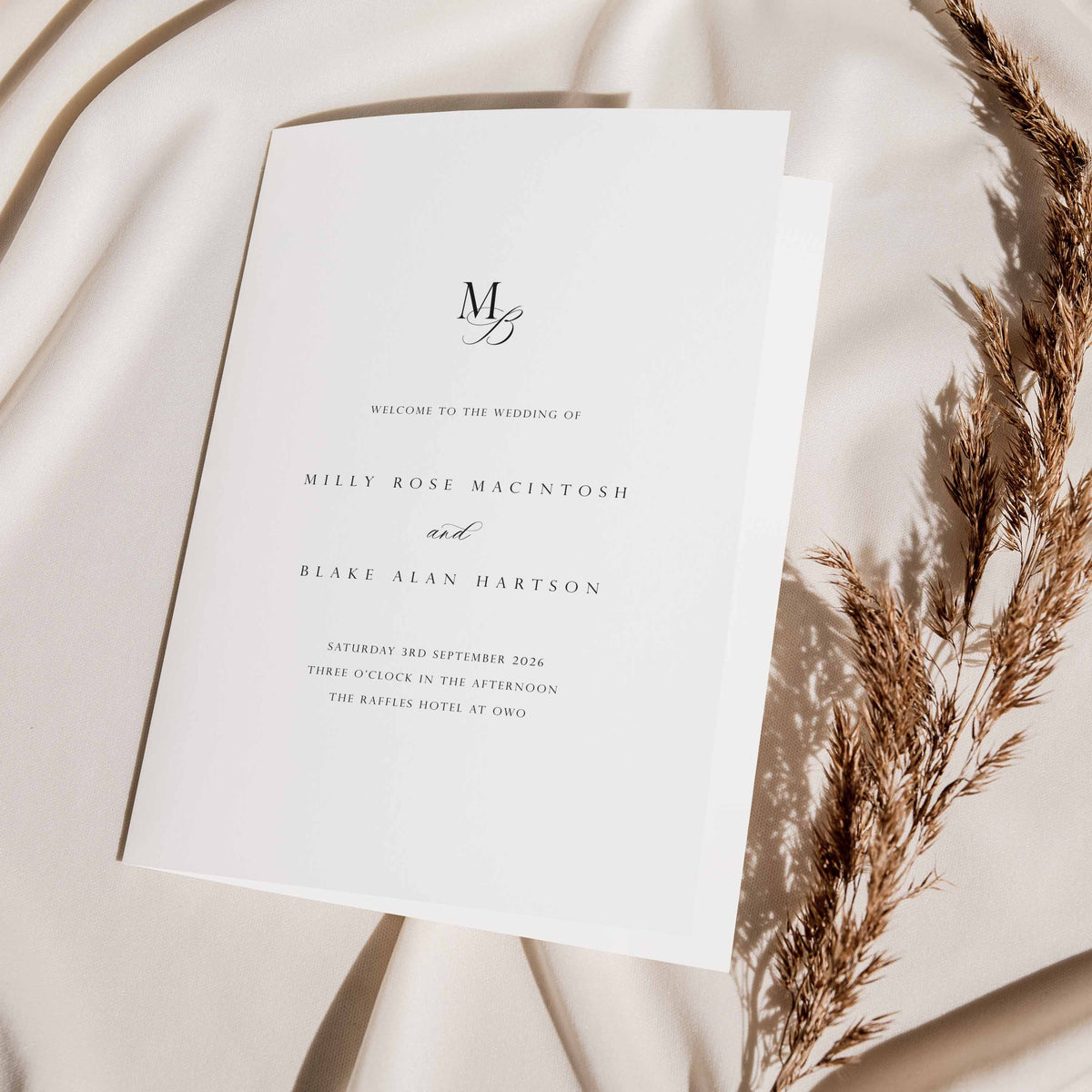 Wedding order of service on a soft fabric background with dried reeds
