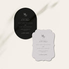 Two wedding save the date cards featuring a black oval card and a scalloped light grey card with elegant serif typography, displayed on a warm off-white background with soft diagonal shadows.