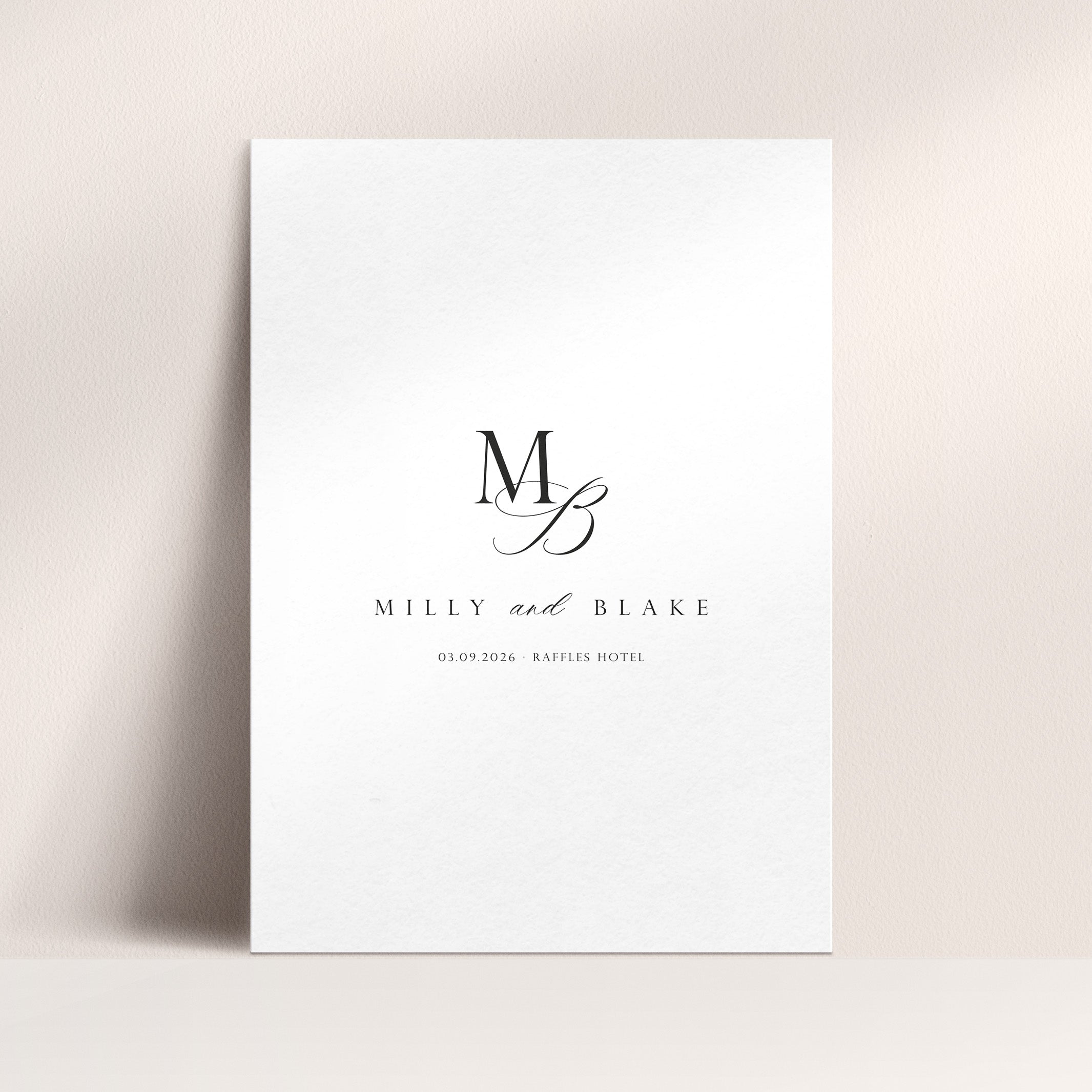 A wedding welcome sign featuring a stylised monogram and elegant text against a neutral background