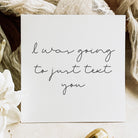 Note with 'I was going to just text you' text on a soft fabric background