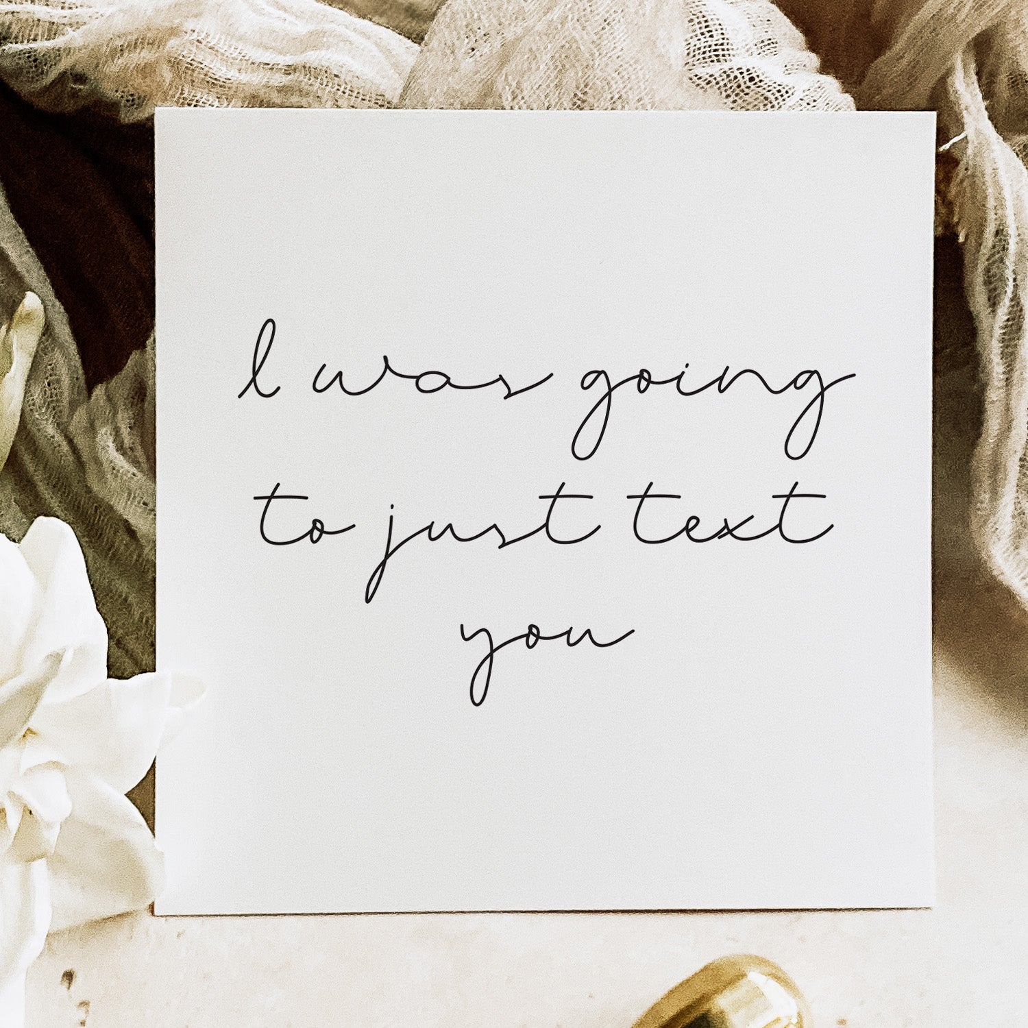 Note with 'I was going to just text you' text on a soft fabric background