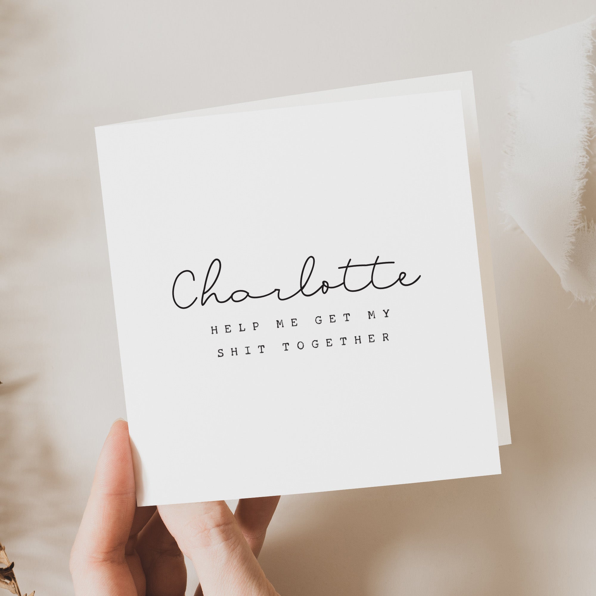 White card with text held by a hand on a neutral background