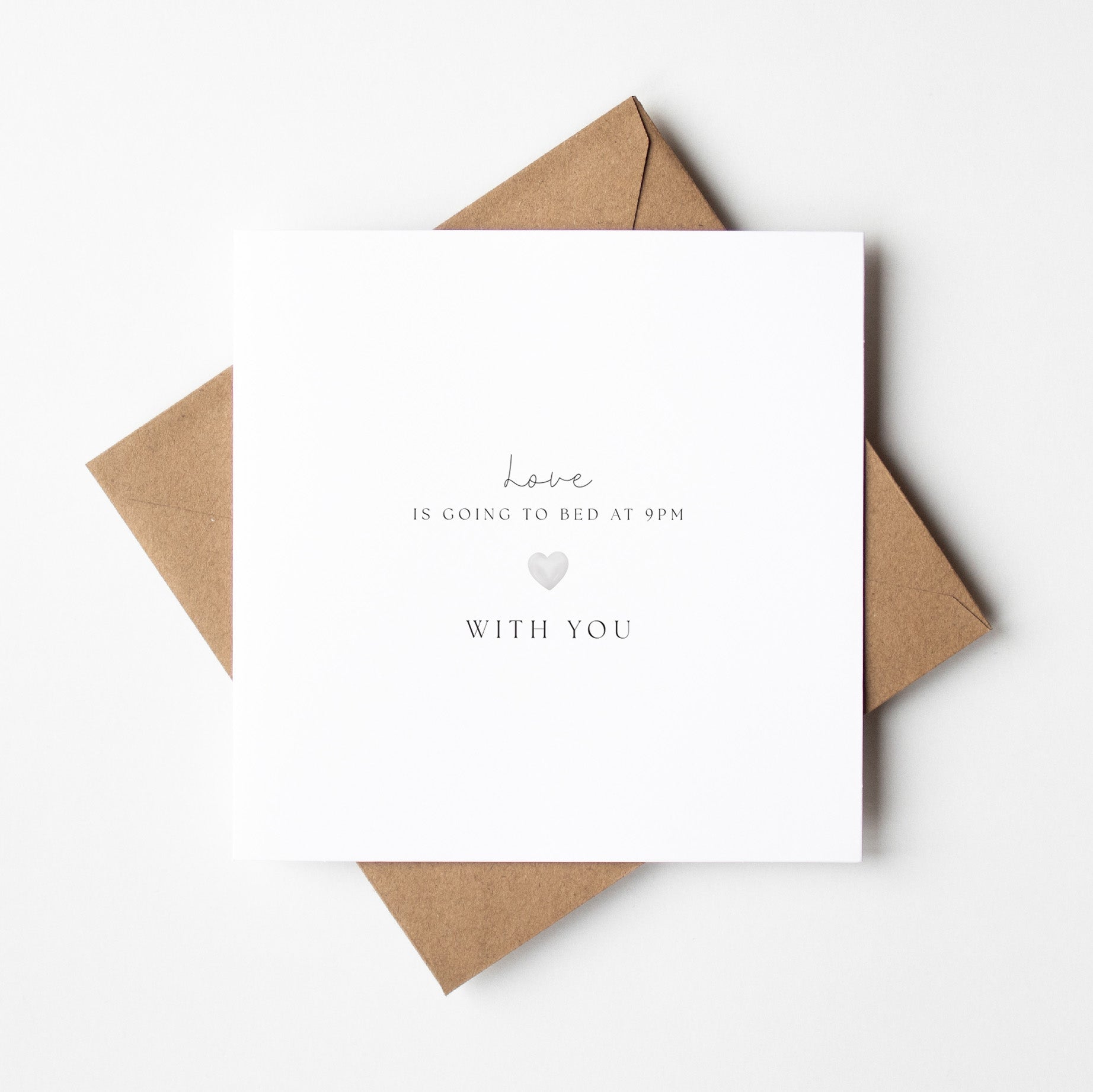 White card with text and a heart symbol on a brown envelope against a white background