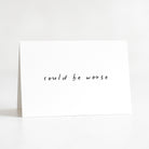 White card with 'could be worse' text on a white background