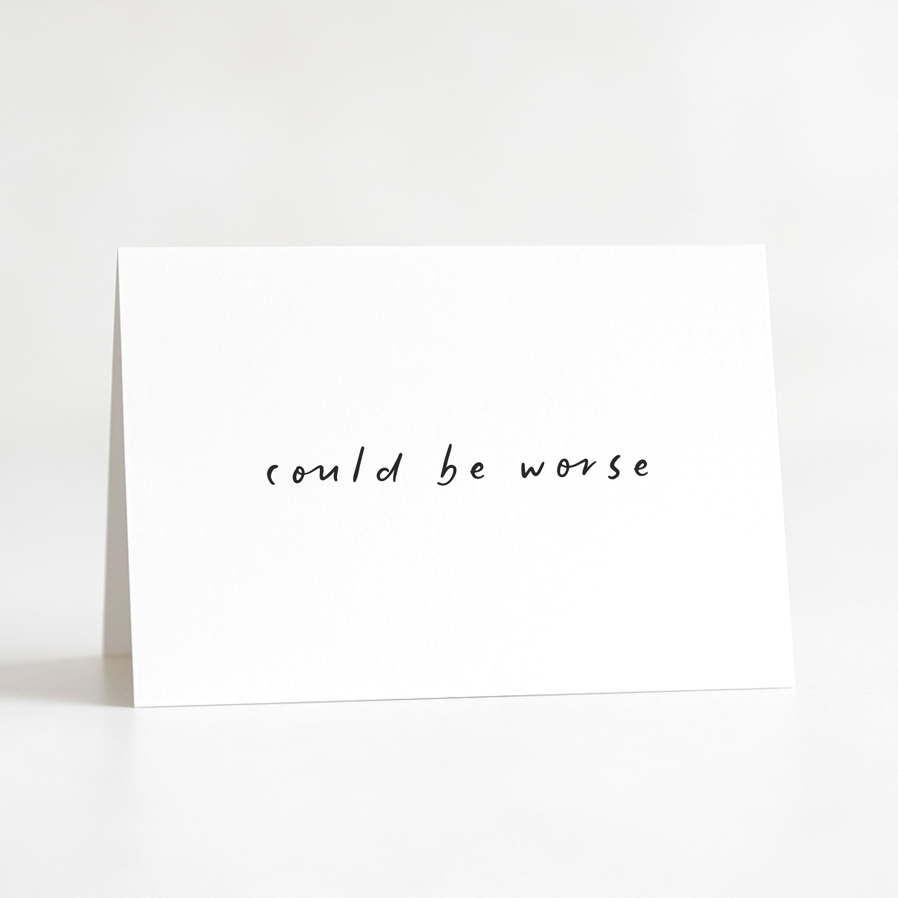 White card with 'could be worse' text on a white background