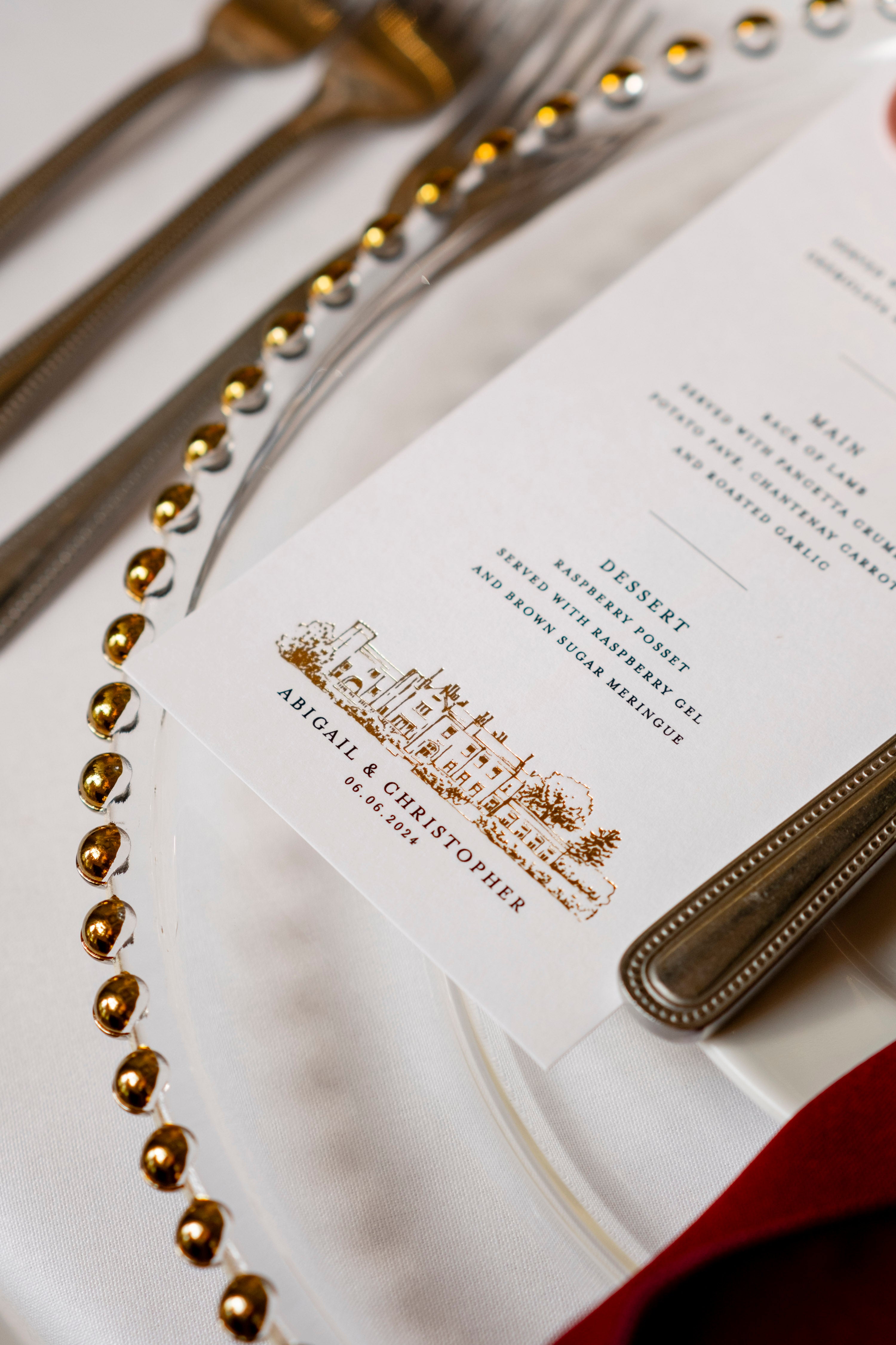 Close-up of a formal dinner setting with cutlery and a menu card.