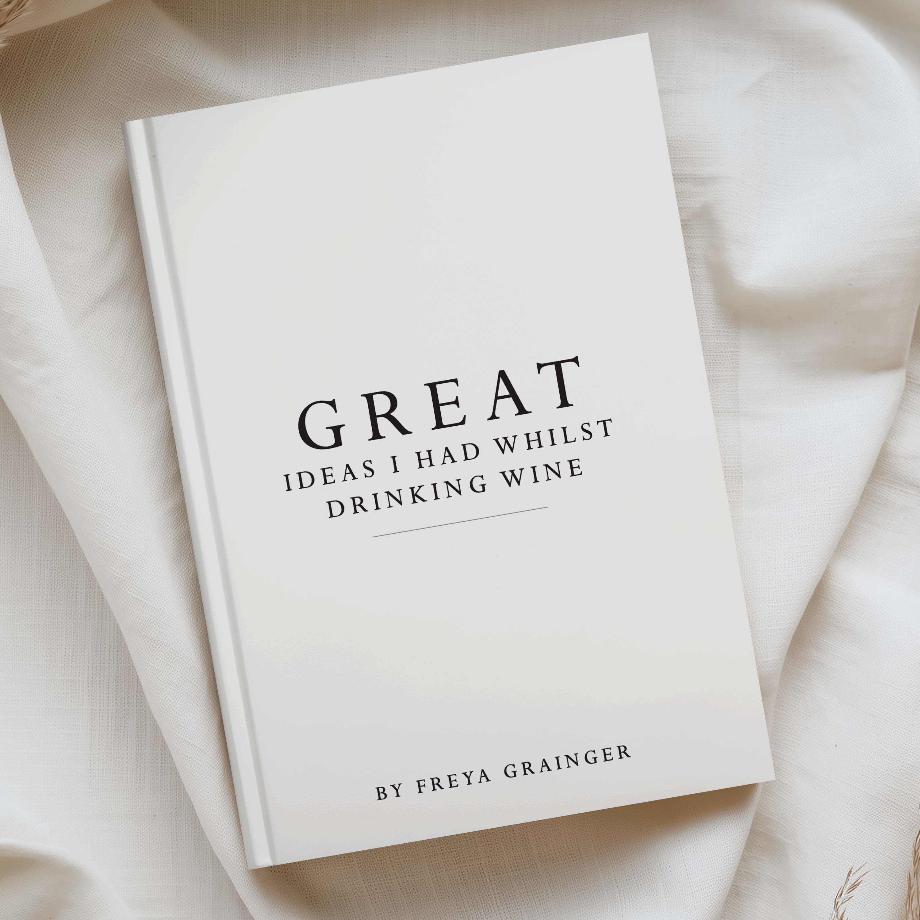 A hardcover book titled 'Great Ideas I Had Whilst Drinking Wine' by Freya Grainger, displayed on a draped cream-colored fabric background.