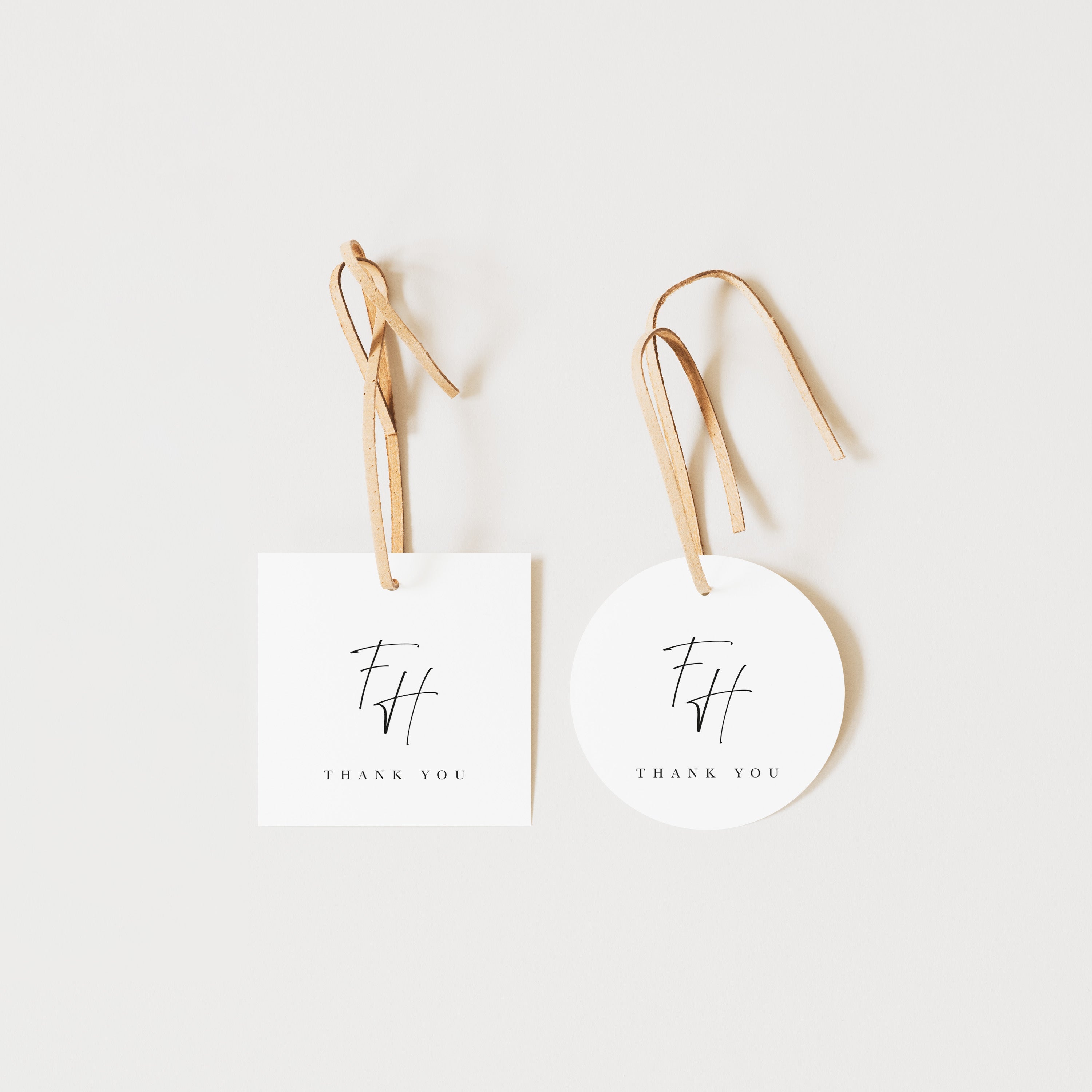 Two white tags with 'THANK YOU' and a logo on a light beige background