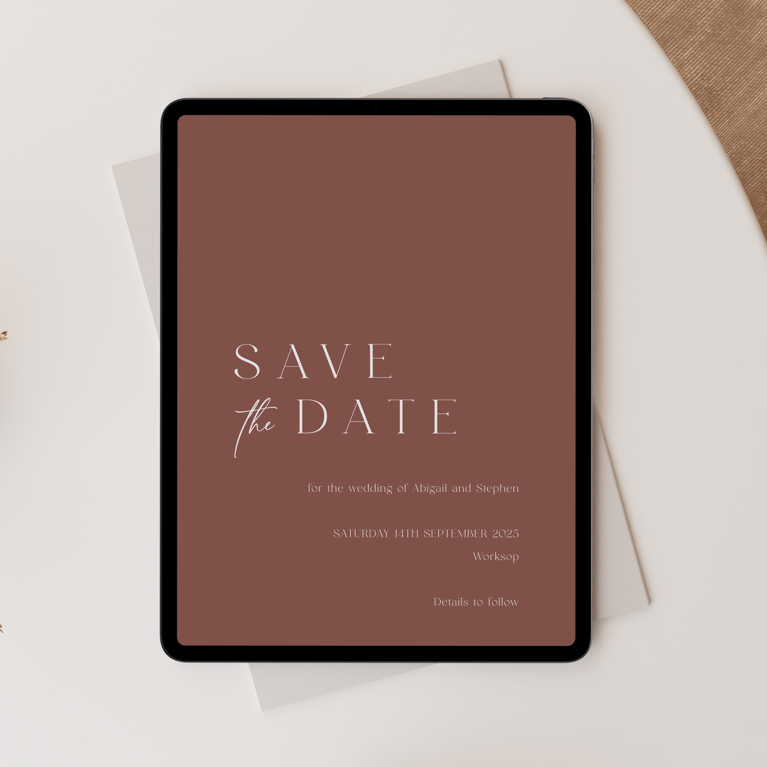 Save the Date card on a tablet with a terracotta background