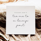 White card with text 'Please don't tie me to a lamp post' on a textured brown background