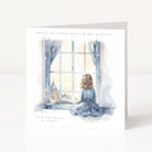 A square Christmas greeting card with a watercolor illustration of a child sitting by a window in winter clothing, looking out at a snowy scene. The card has a white border with the text 'merry christmas and a happy new year' at the top and 'from our home to yours' at the bottom.