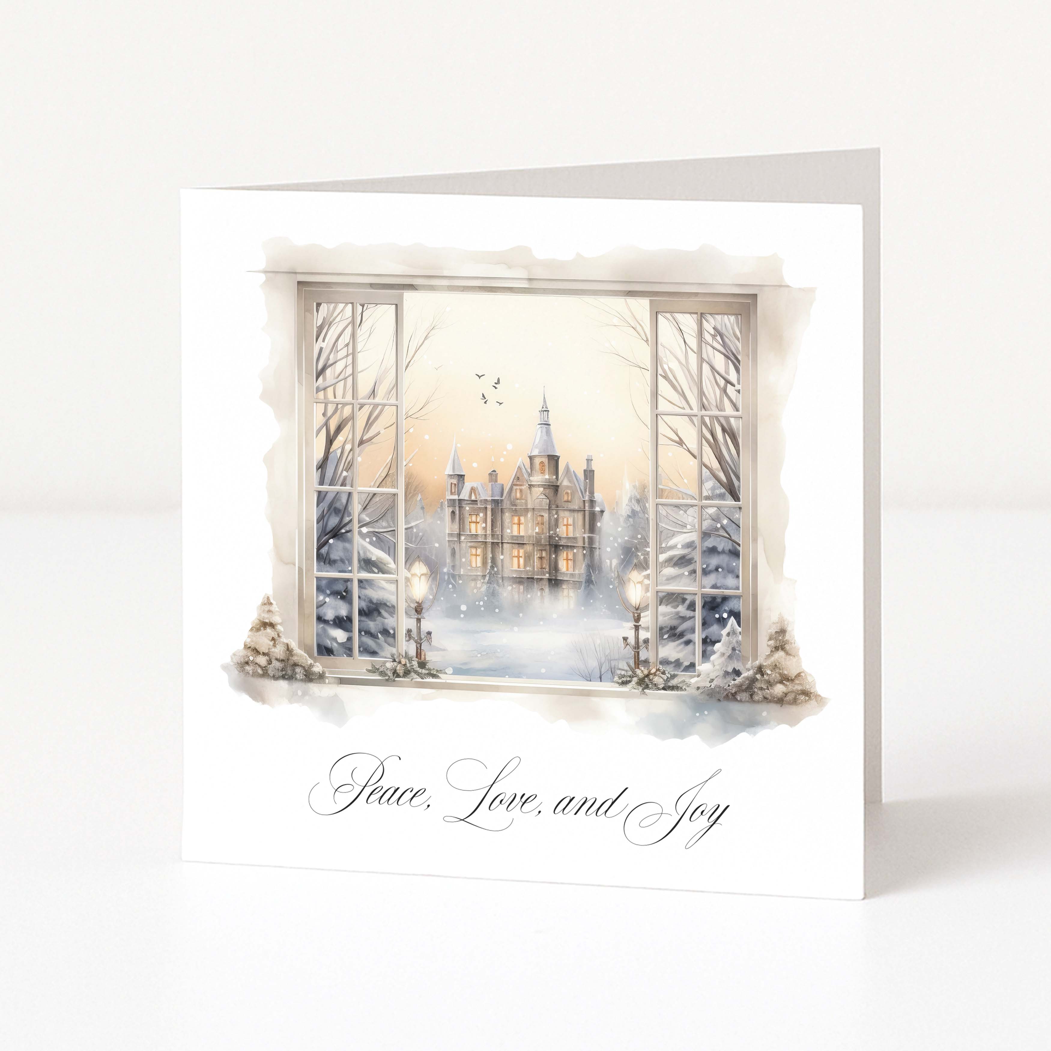 A white greeting card standing upright on a white surface, featuring a watercolor winter scene printed on the front: an open window view of a castle at dusk, snow-covered trees, and the words 'Peace, Love, and Joy' in black script below.