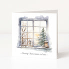 A square white Christmas greeting card standing upright on a white surface. The front features an illustrated snowy window scene with bare trees, a evergreen tree, lanterns, and the text '~ Merry Christmas to You ~' below the artwork.