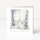 A square white greeting card standing upright, printed with an illustration of a snowy window scene and the text 'DREAMING OF A White Christmas' near the bottom.