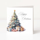 A square Christmas greeting card shown standing upright against a clean white background. The card features a watercolor-style decorated Christmas tree with ornaments, a gold star on top, and several wrapped presents underneath, with the words 'Happy Christmas' in elegant black script on the right.