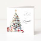 A white Christmas greeting card featuring a watercolor-style Christmas tree with red ornaments, wrapped gifts, and the words 'ALL IS Calm' and 'ALL IS Bright' in black script, shown standing against a clean white background.