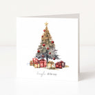 A white square Christmas greeting card standing upright, printed with a watercolour Christmas tree decorated with red ornaments and wrapped presents beneath a gold star, with the phrase 'Jingle all the way' at the bottom.