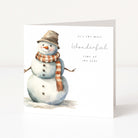 A square white Christmas greeting card featuring a watercolor snowman wearing a brown hat and an orange-and-white striped scarf, with the text 'it's the most Wonderful time of the year' on a clean white background.