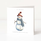 A white Christmas greeting card featuring a watercolour illustration of a snowman wearing a brown knit hat with a pom-pom and a blue-grey striped scarf. The text at the top reads 'it's the most' and the text at the bottom reads 'wonderful time of the year'.