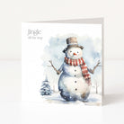 A square Christmas greeting card featuring a watercolour illustration of a snowman wearing a brown top hat and a red-and-white striped scarf, with the text 'jingle all the way' on a white background.