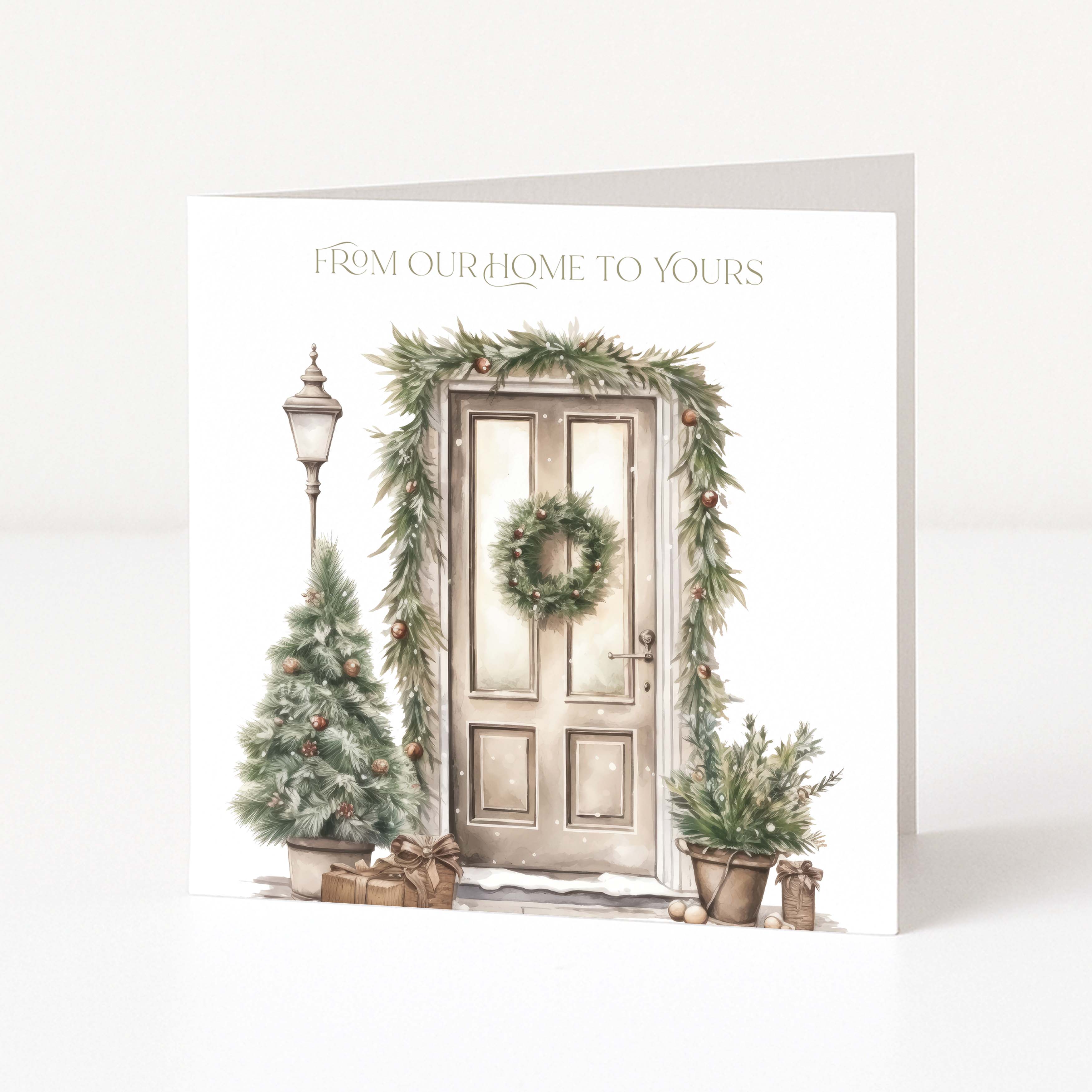 A square greeting card shown standing upright against a clean white background. The front of the card features a watercolor-style illustration of a holiday door scene with a wreath, evergreen garland, small Christmas tree, lamp post, potted plants, and wrapped gifts.