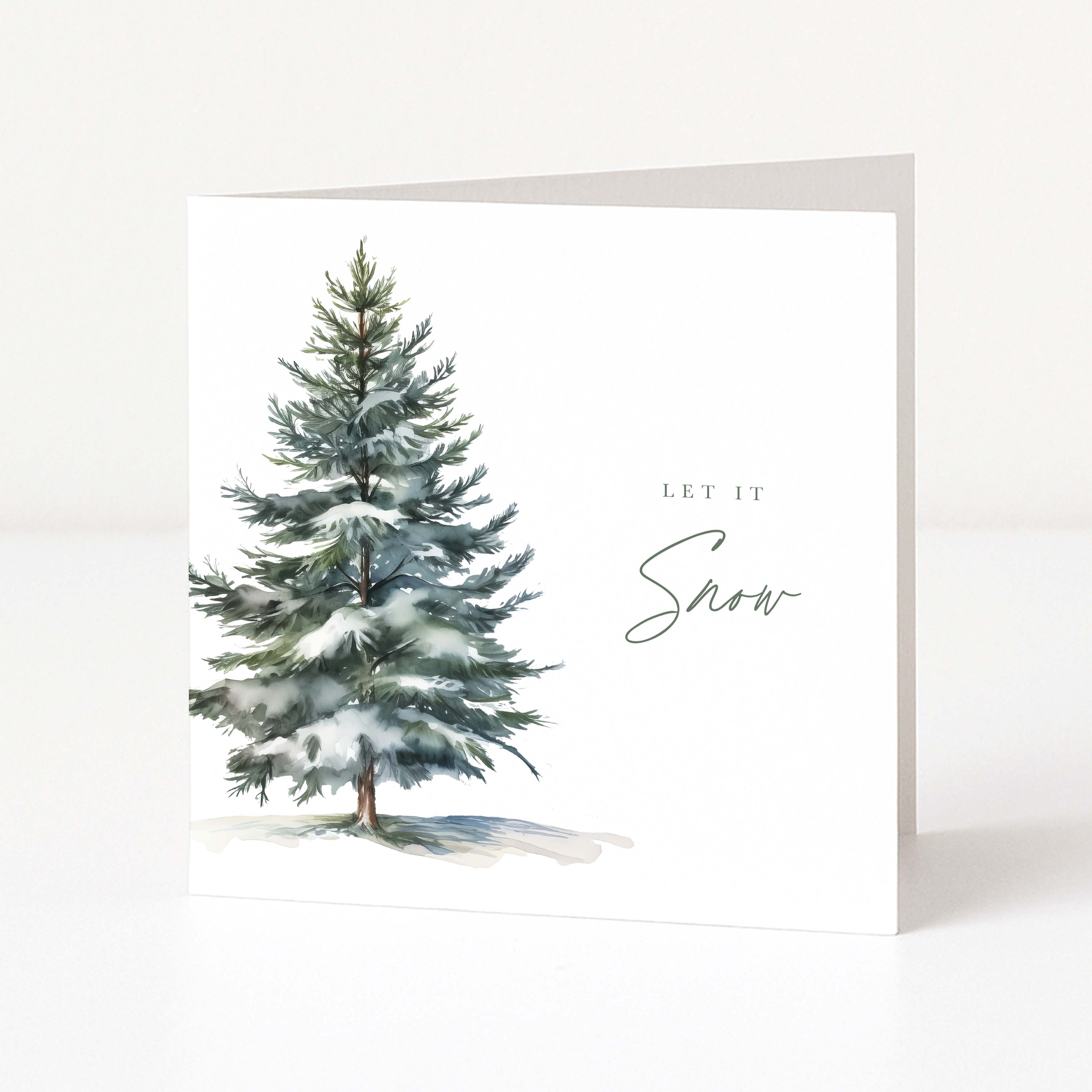 A white Christmas greeting card featuring a watercolor illustration of a snow-dusted evergreen tree on the left and the words 'LET IT Snow' in black script and serif text on the right, shown standing against a clean white background.