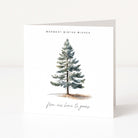 A white Christmas greeting card standing upright on a light surface, featuring a watercolour-style evergreen tree with the text 'WARMEST WINTER WISHES' above and 'from our home to yours' below.