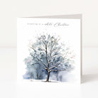 A square Christmas greeting card standing upright on a white surface, featuring a watercolour winter tree illustration with the text 'dreaming of a white Christmas' near the top.