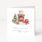 A white Christmas greeting card standing upright, featuring a watercolor illustration of a decorated fireplace, Christmas tree, red armchair, and gifts, with the text 'MERRY CHRISTMAS and a happy new year' below.