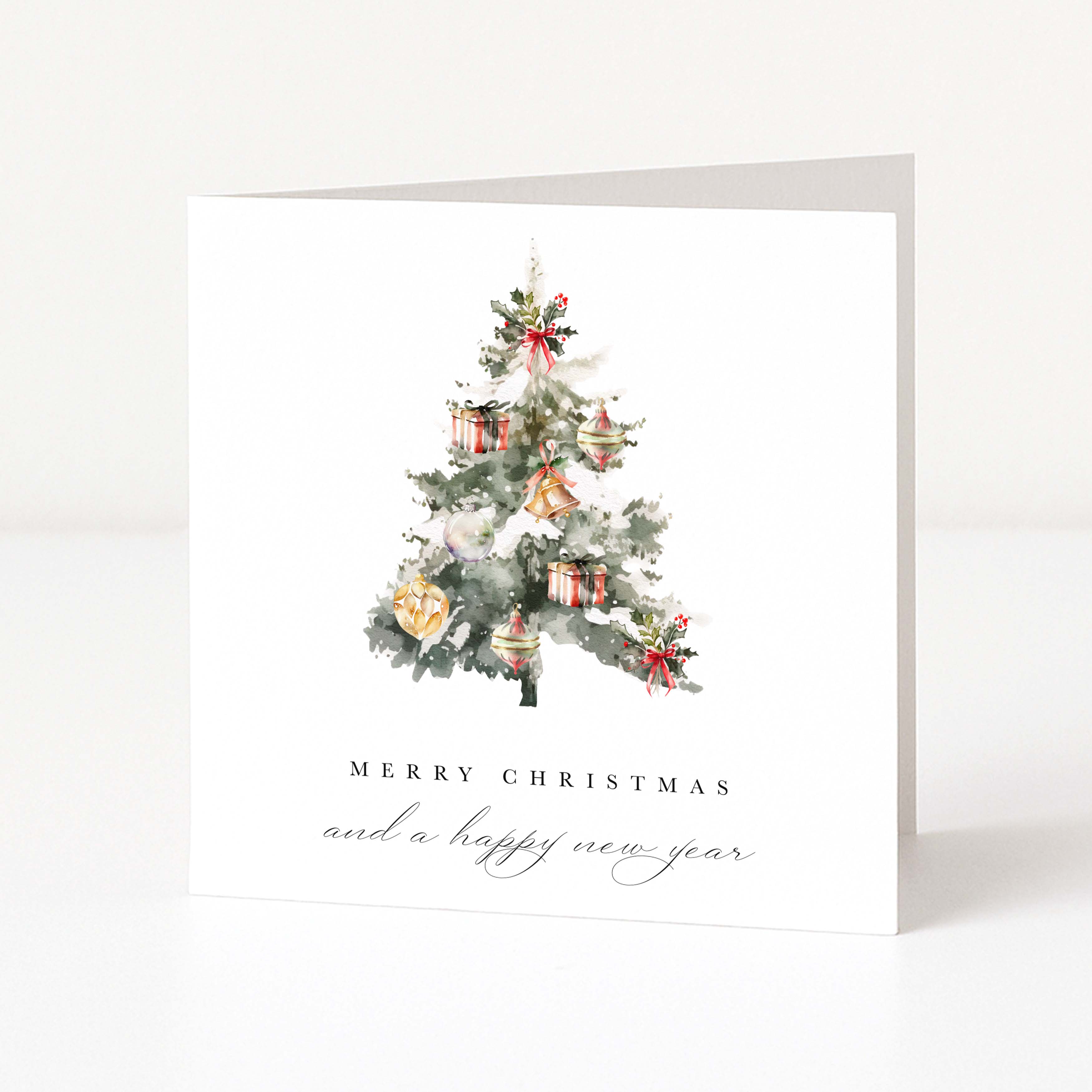 A white Christmas greeting card standing upright, featuring a watercolour illustration of a decorated tree with ornaments and the text 'MERRY CHRISTMAS and a happy new year' below.